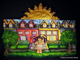 Textured Sculptamold relief sculpture of colorful houses, green trees, and a golden sun against a black background.